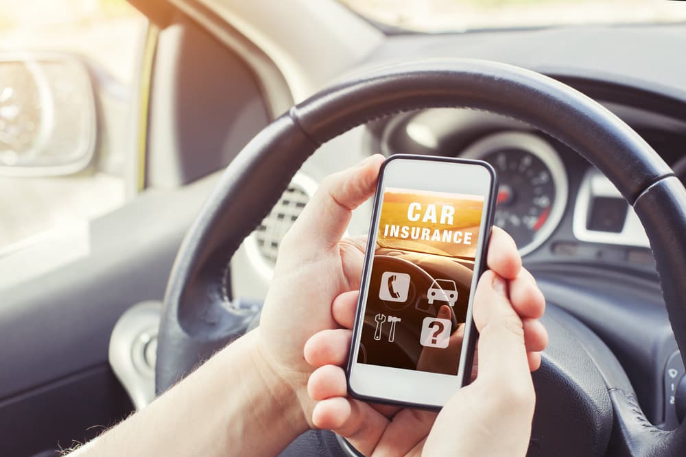 car insurance concept, driver accessing website on smartphone