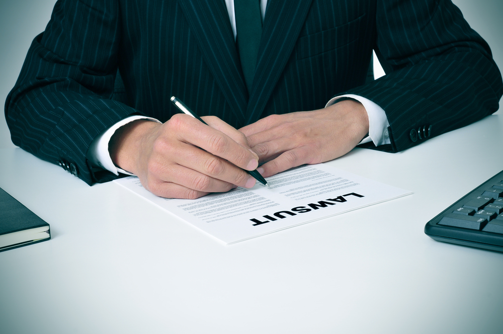 The image of the lawyer in his office with a document titled "Lawsuit."