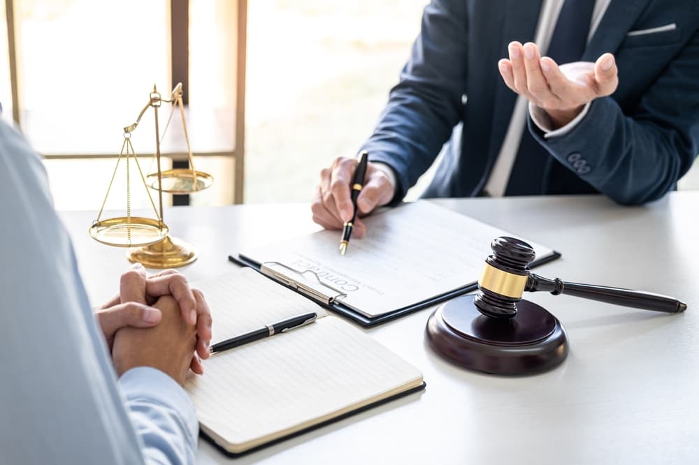 A consultation between a male lawyer and a client is taking place in a law firm office. 