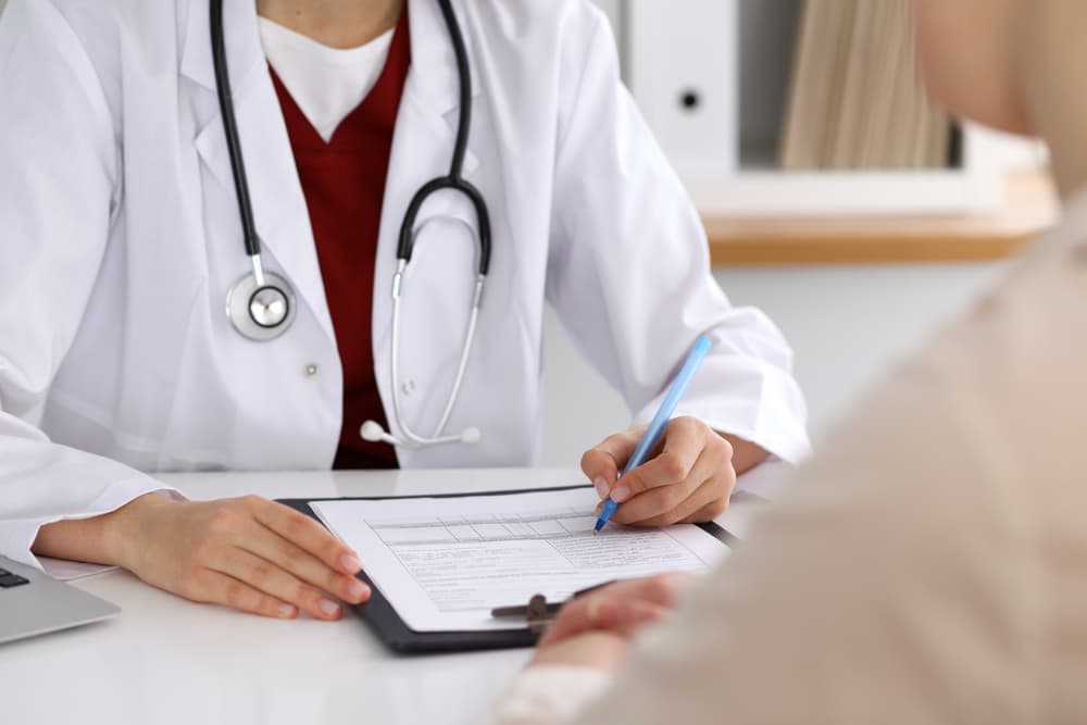 A close-up of a female doctor consulting a patient, highlighting themes of healthcare and medical care.