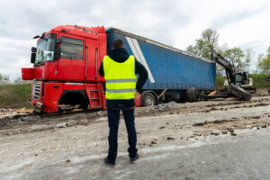 Highway freight truck accident: a semi-trailer with damaged cargo crashed along the freeway shoulder.